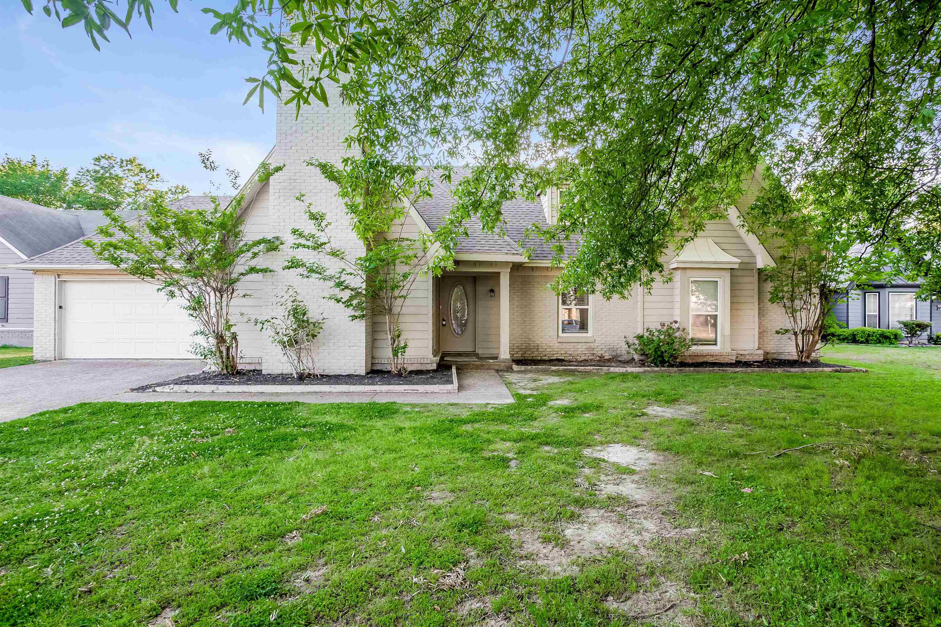 View of front of property featuring a garage and a front yard