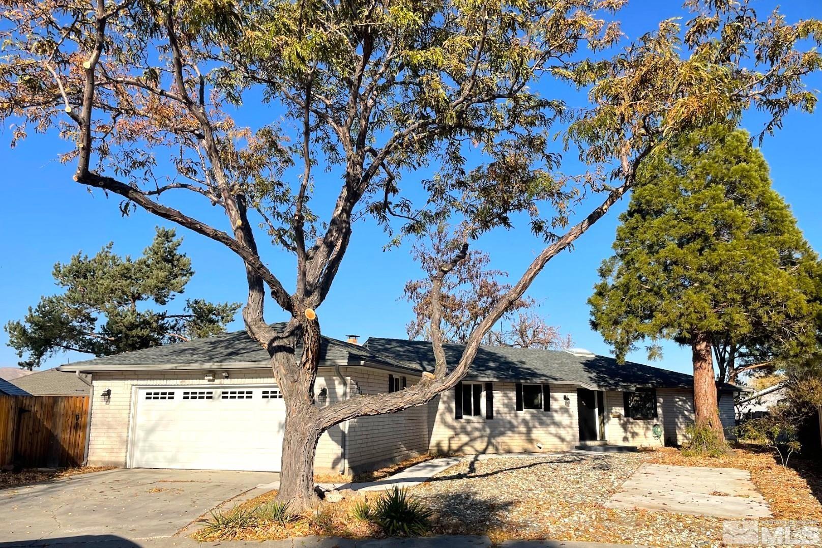 a front view of a house with a yard covered with snow