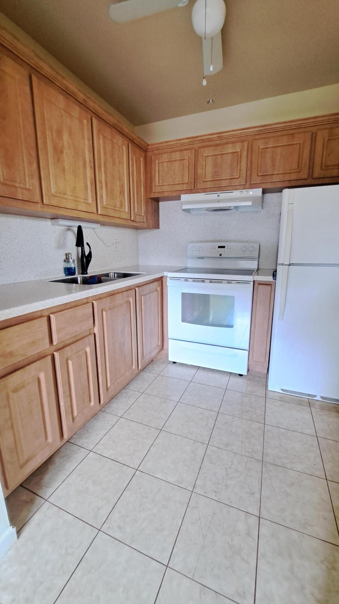 a kitchen with granite countertop a stove a sink and a white cabinets