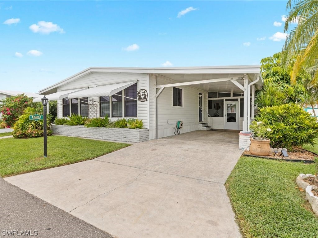 a front view of a house with a yard and potted plants