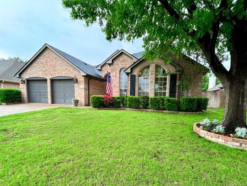 a front view of a house with a yard and trees