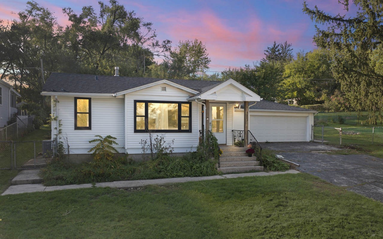 a front view of a house with a garden and yard