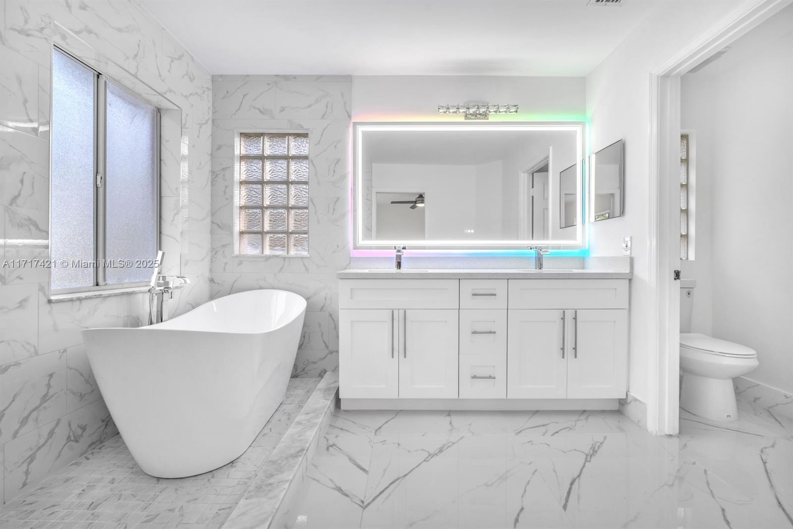 a spacious bathroom with a tub sink and mirror