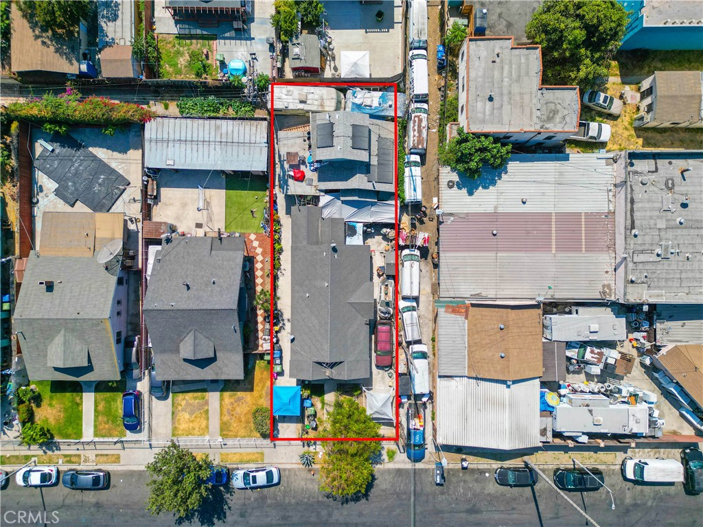 an aerial view of residential houses with outdoor space and parking