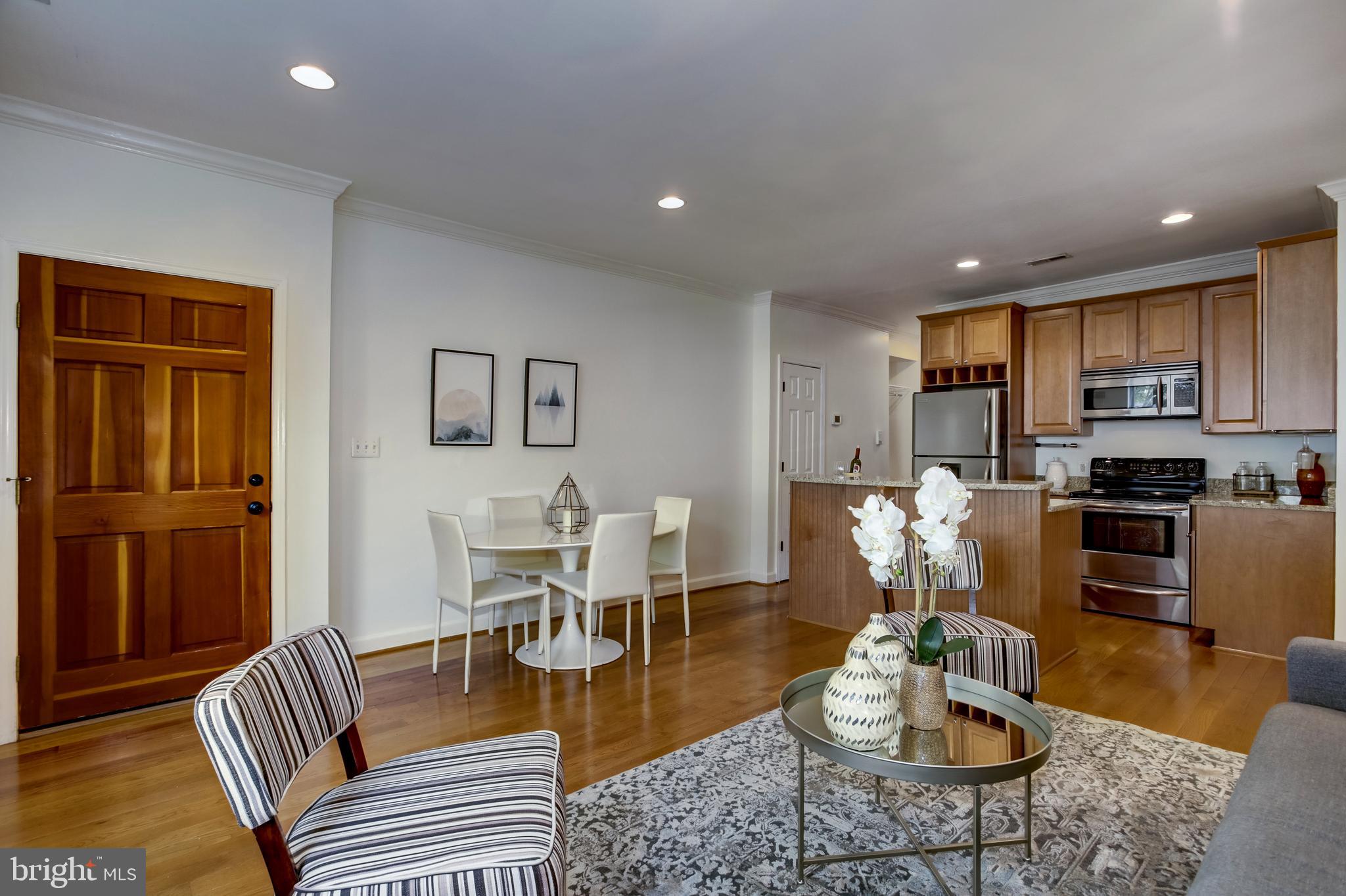 a living room with furniture kitchen and a refrigerator