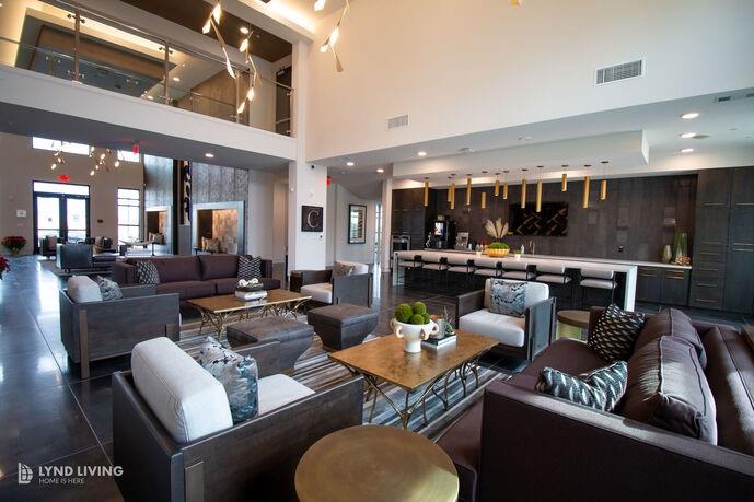 a living room with furniture kitchen view and a large window