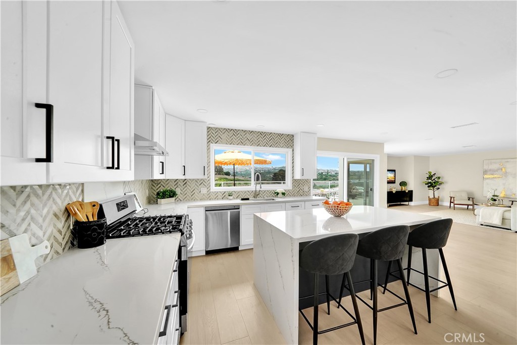 a kitchen with a dining table chairs and white cabinets