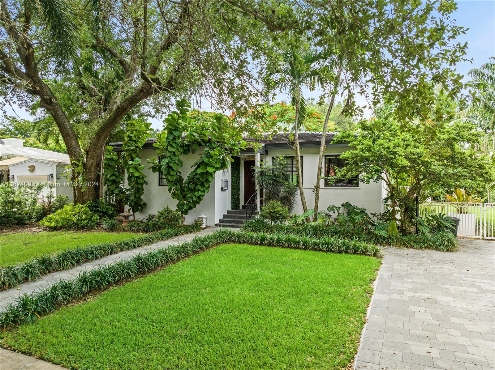 a front view of a house with a yard and fountain