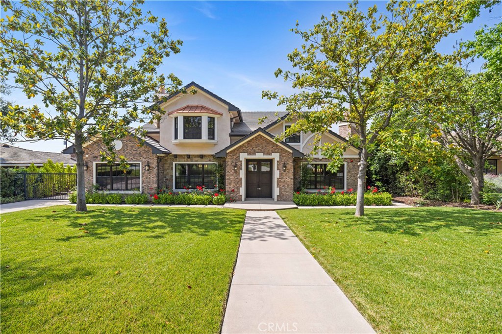 a front view of a house with a yard and trees