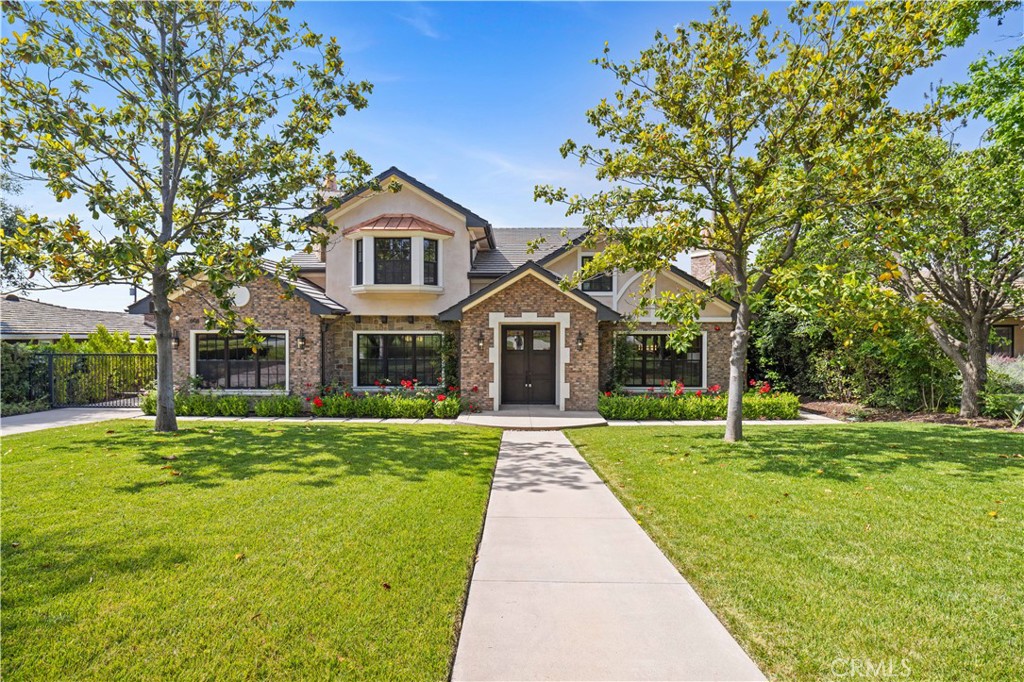 a front view of a house with a yard and trees