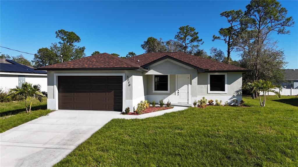 a front view of a house with a garden and yard