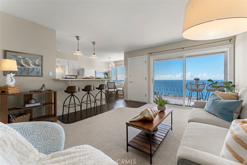 a living room with furniture kitchen view and a chandelier