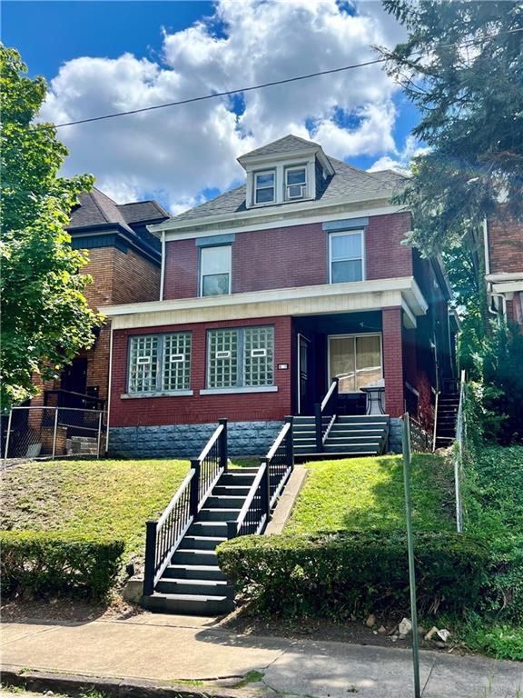 a view of a brick house with a yard