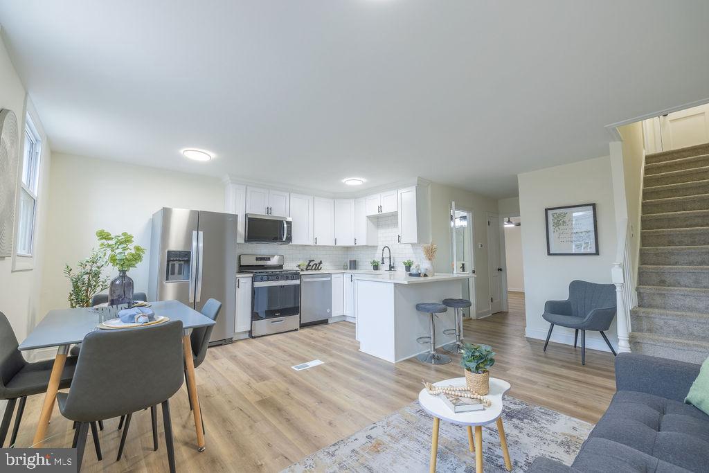 a kitchen with a dining table chairs stainless steel appliances and cabinets