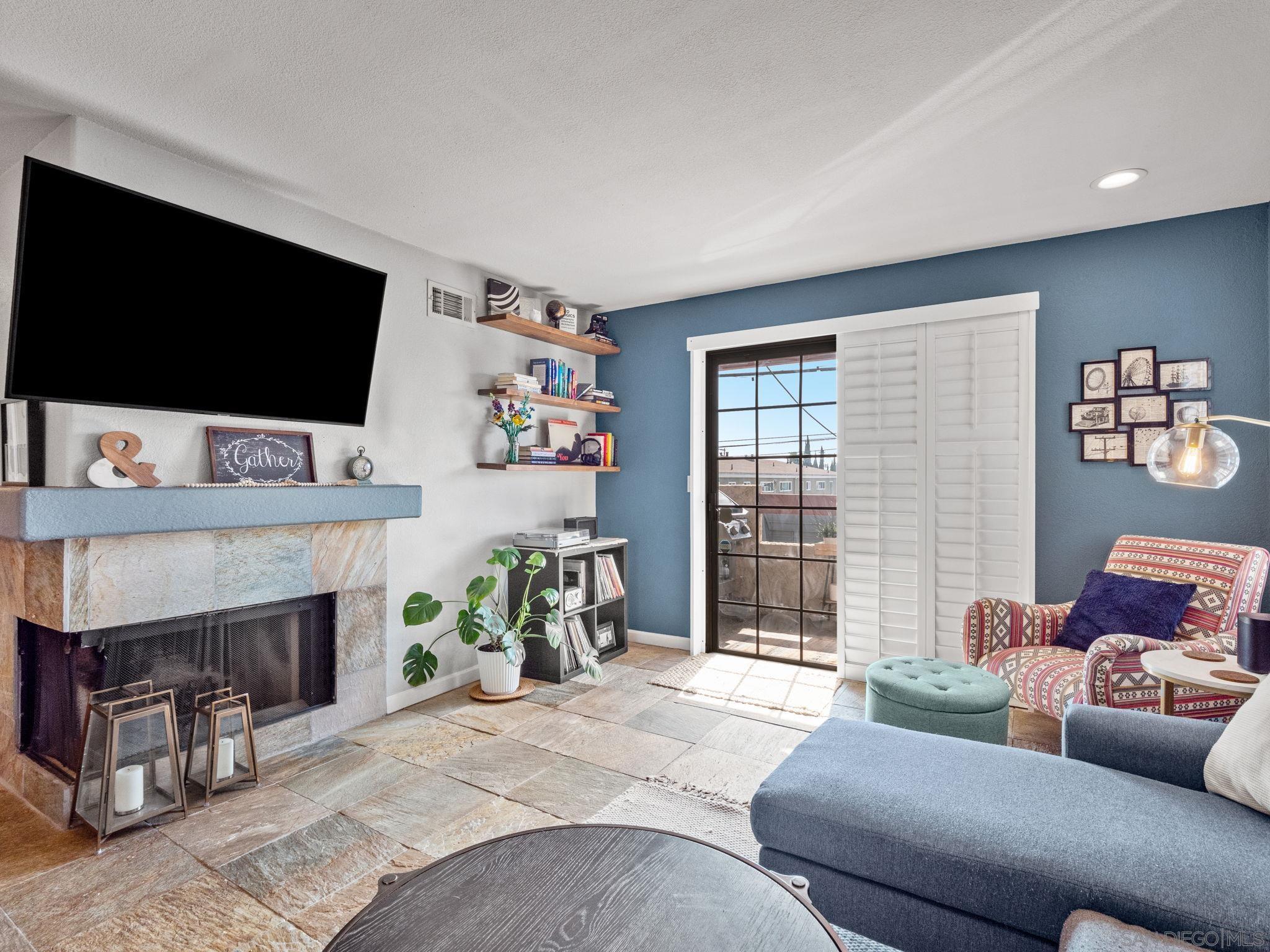 a living room with furniture a flat screen tv and a fireplace