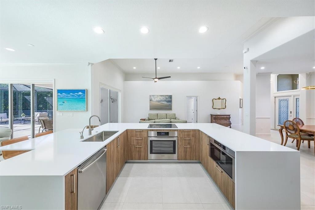 a large kitchen with stainless steel appliances lots of counter space and a sink