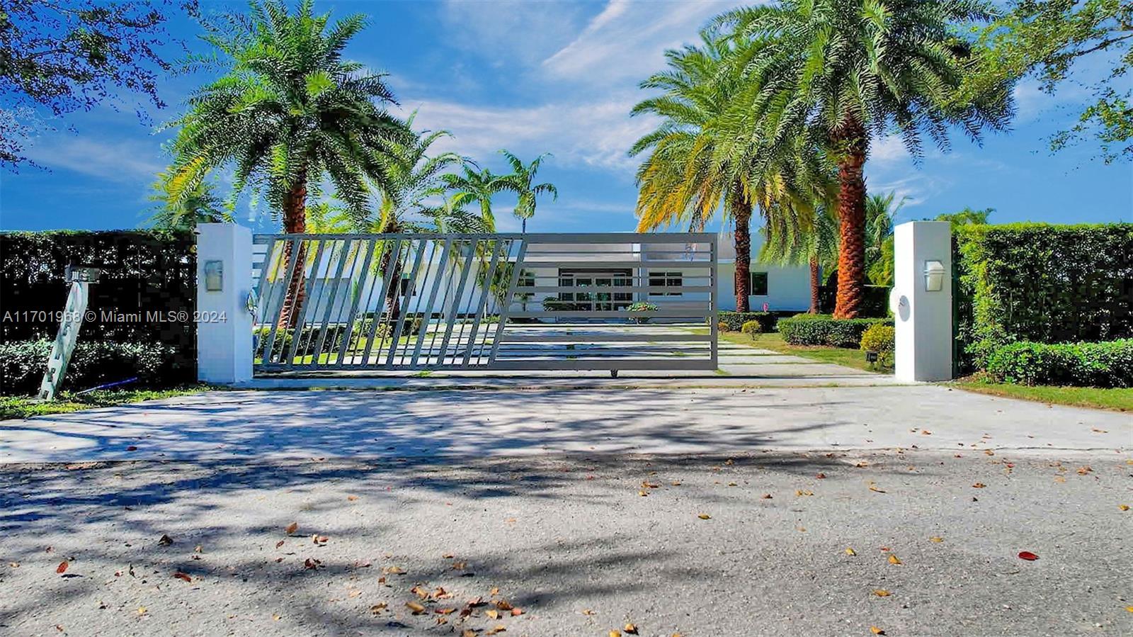 a palm tree sitting in front of a house with a small yard