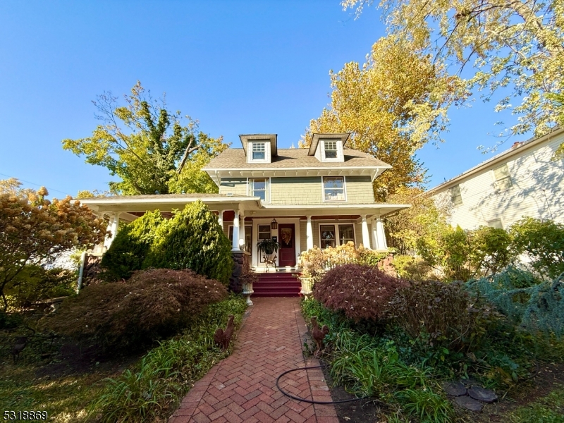 a view of a white house with a yard and potted plants