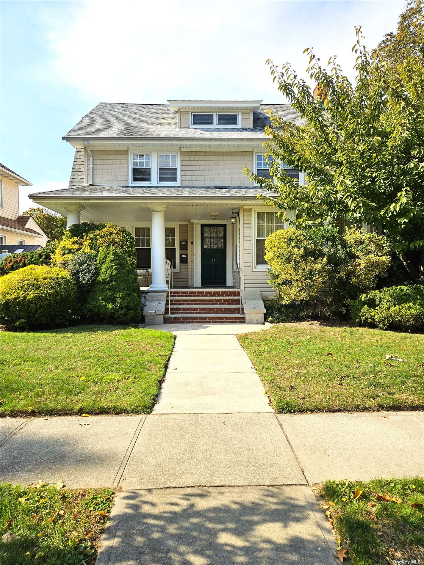 a front view of a house with a yard and potted plants