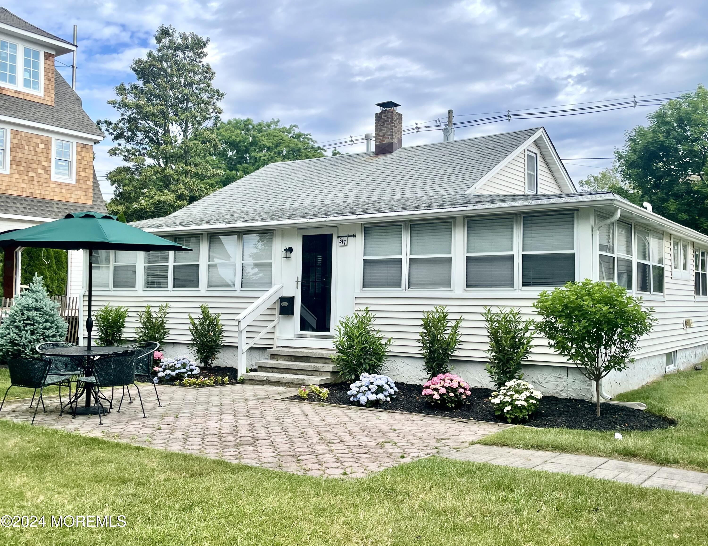 a front view of a house with a yard and outdoor seating