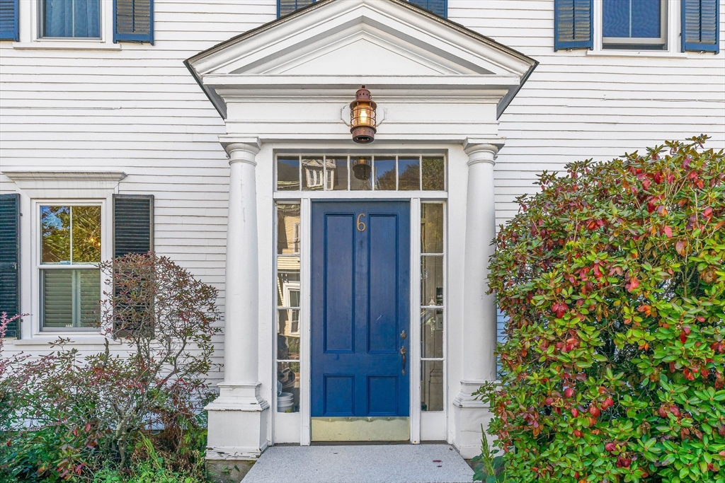 front view of a house with a front door and potted plants