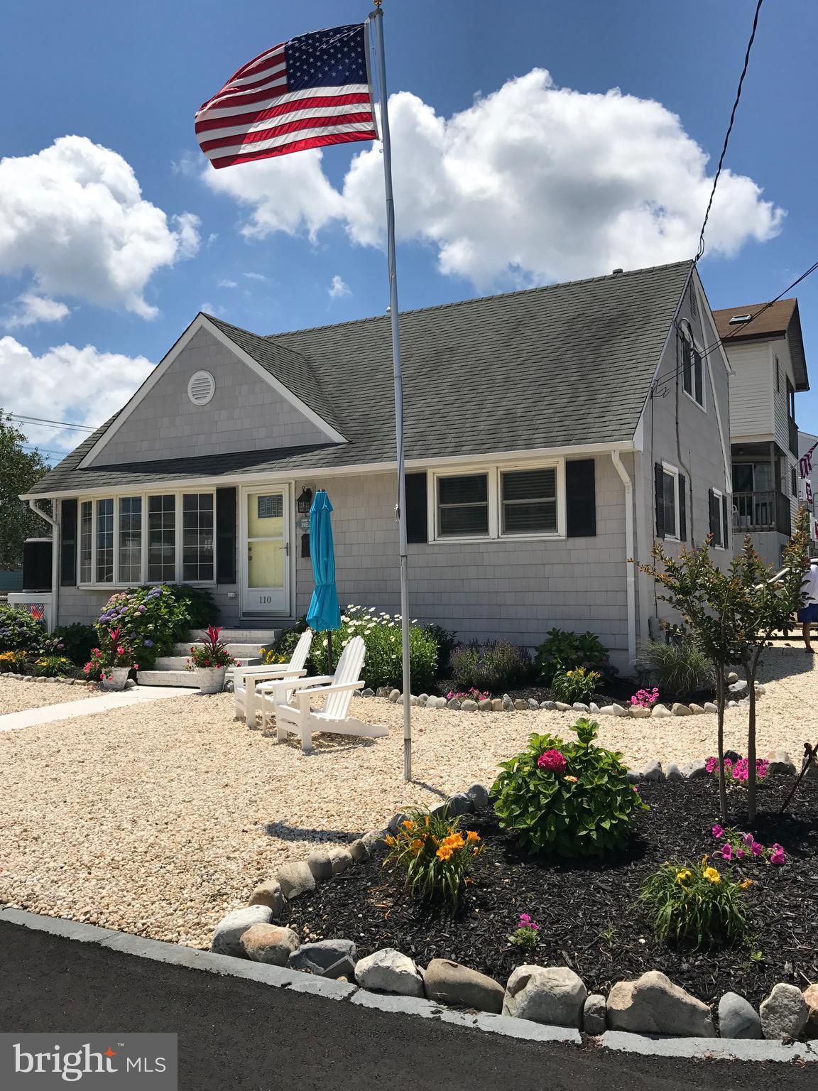 a front view of a house with yard and trees