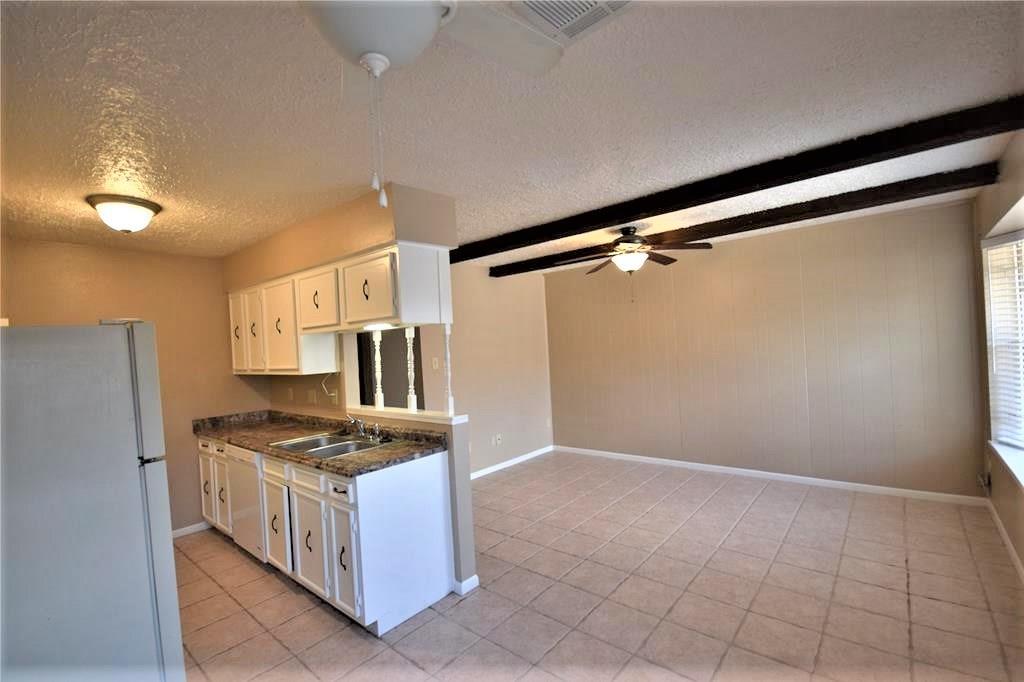 a kitchen with granite countertop a cabinets and a stove top oven