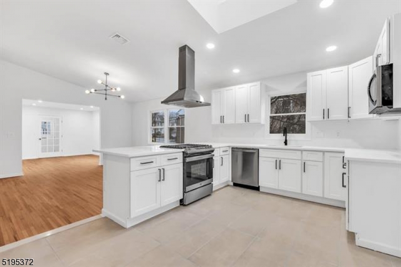 a large kitchen with a large window and stainless steel appliances