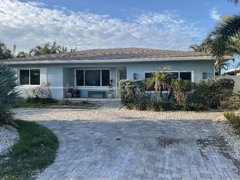 a front view of house with yard and trees around