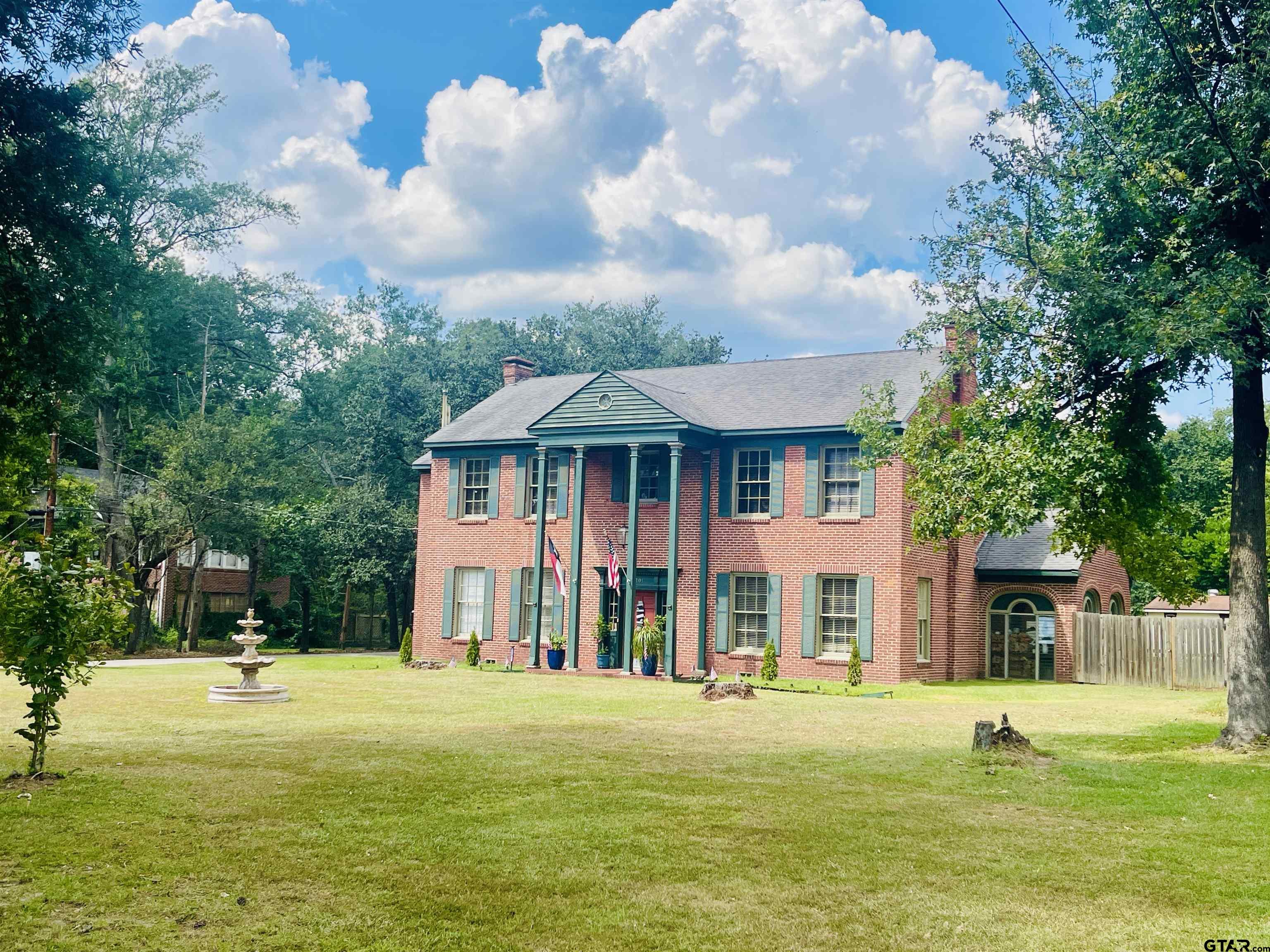 a front view of a house with a yard and trees