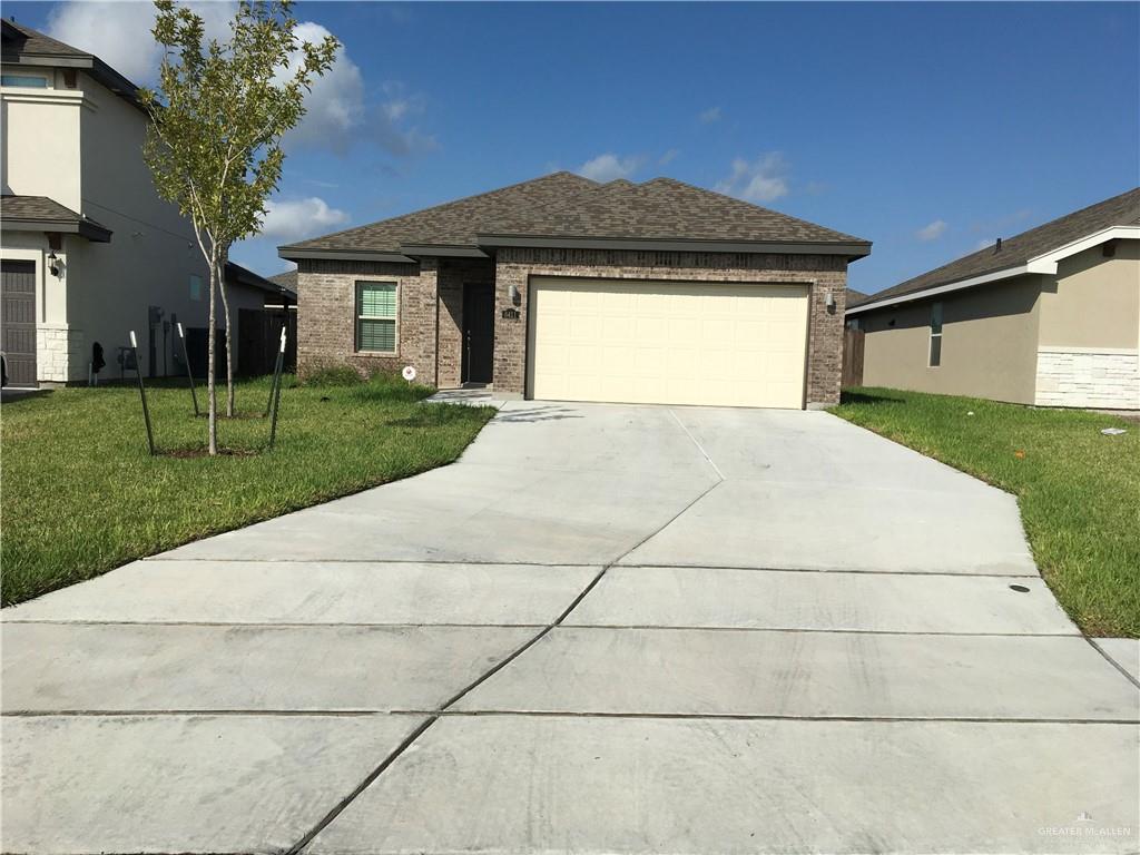 a front view of a house with a yard and trees