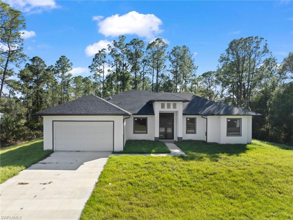 View of front of home featuring a garage and a front yard