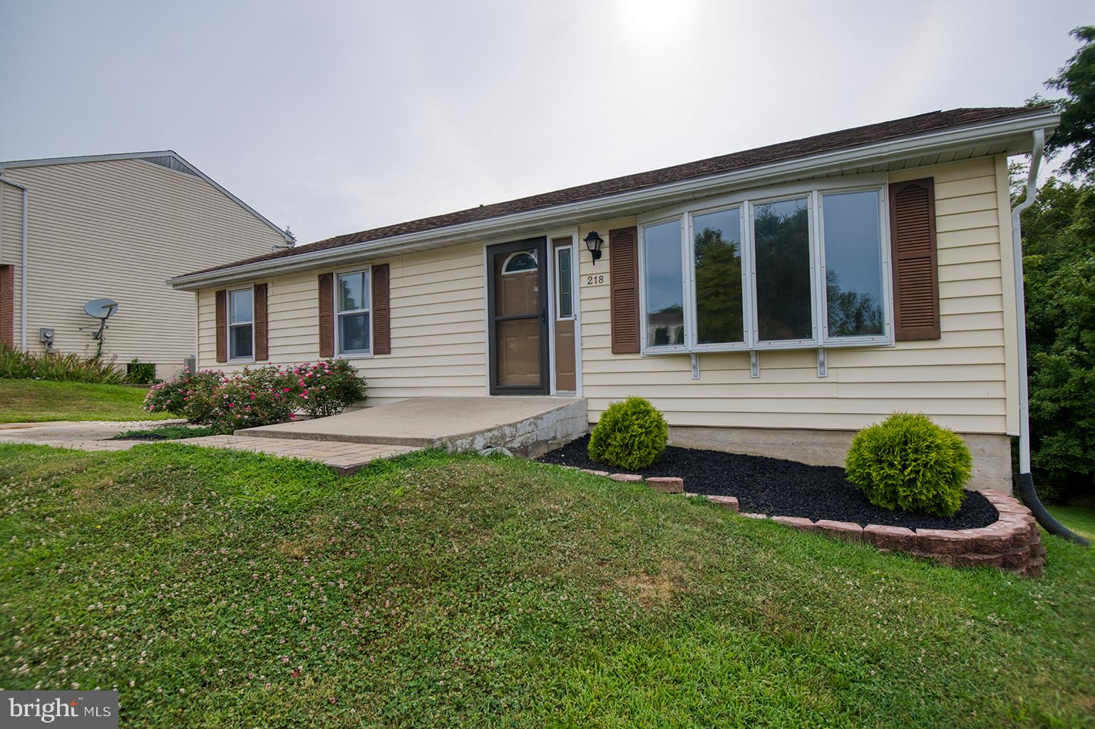 a front view of a house with garden and porch