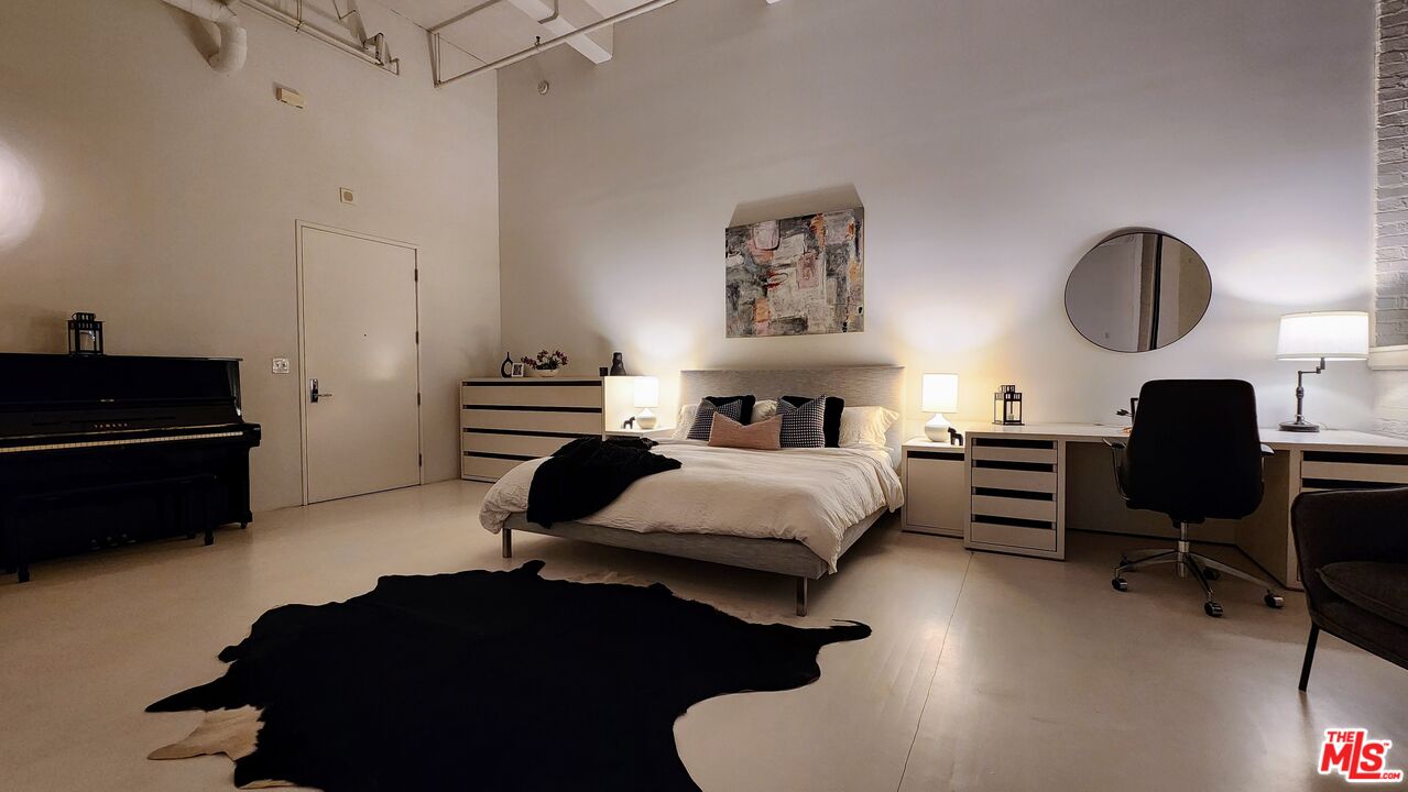 a bedroom with a bed wooden floor and a dresser