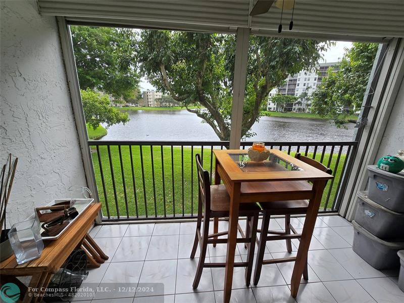 a view of a chairs and table in the patio next to a yard