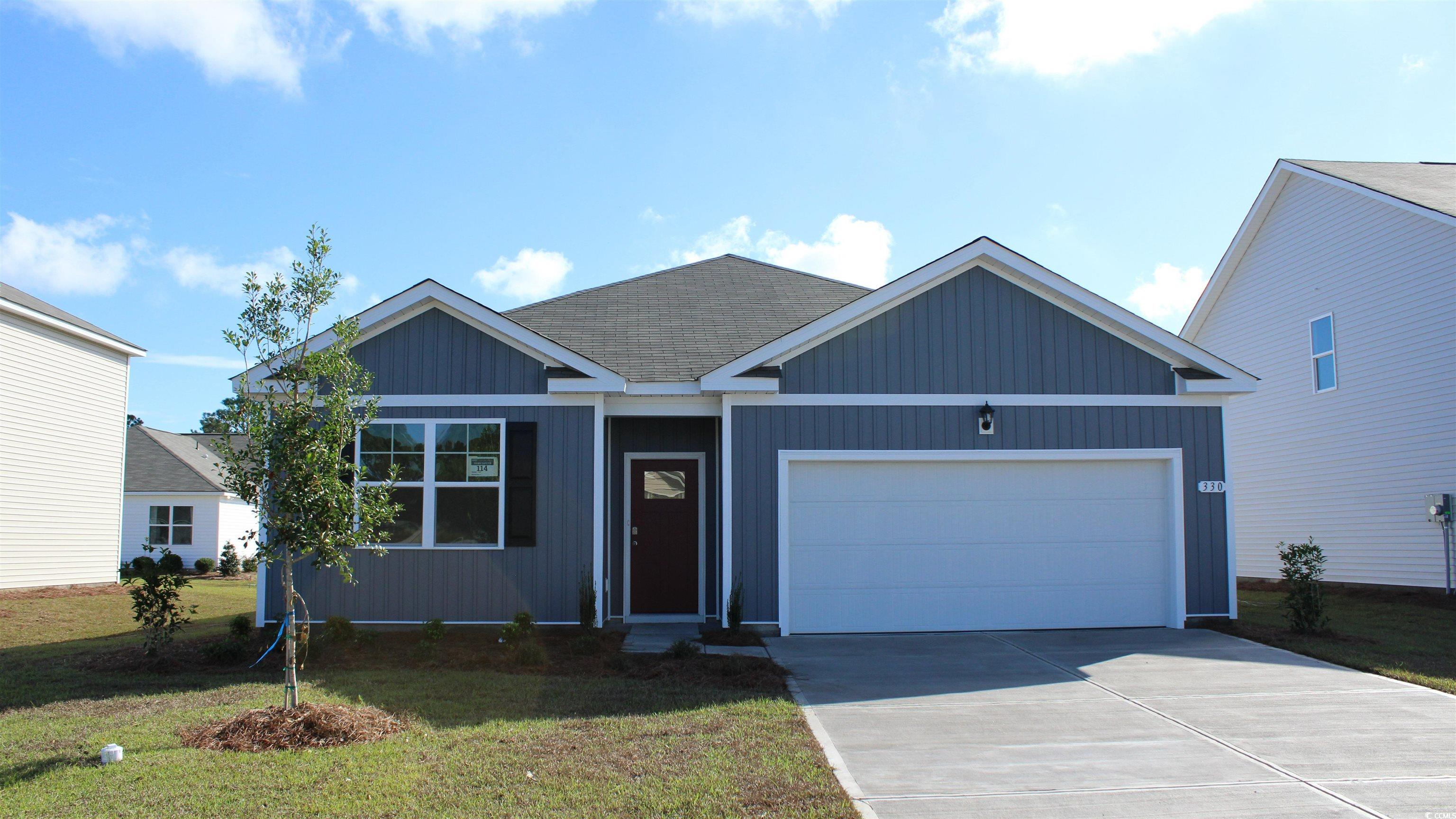 View of front of home with a front lawn and a gara