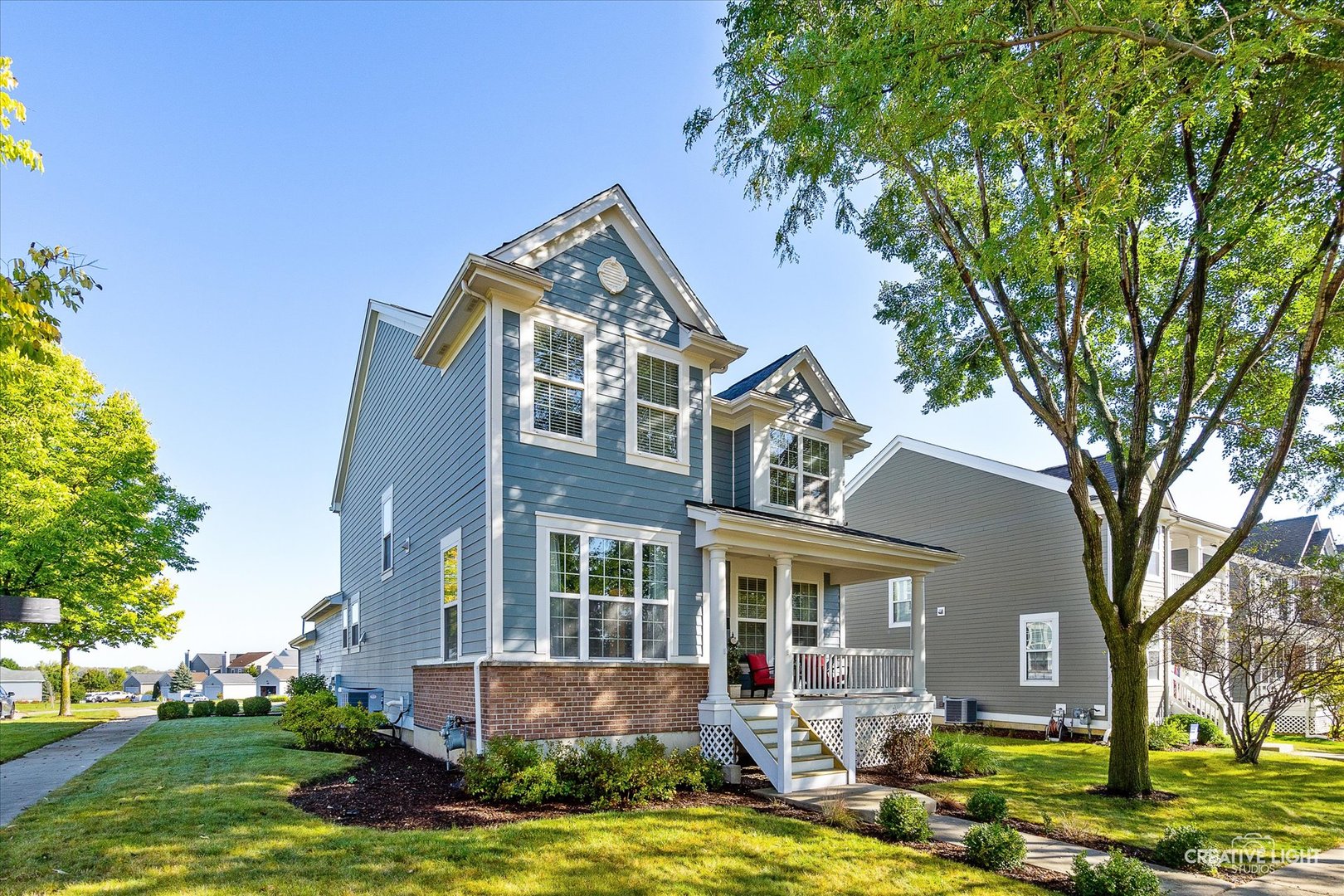 a front view of a house with yard and green space