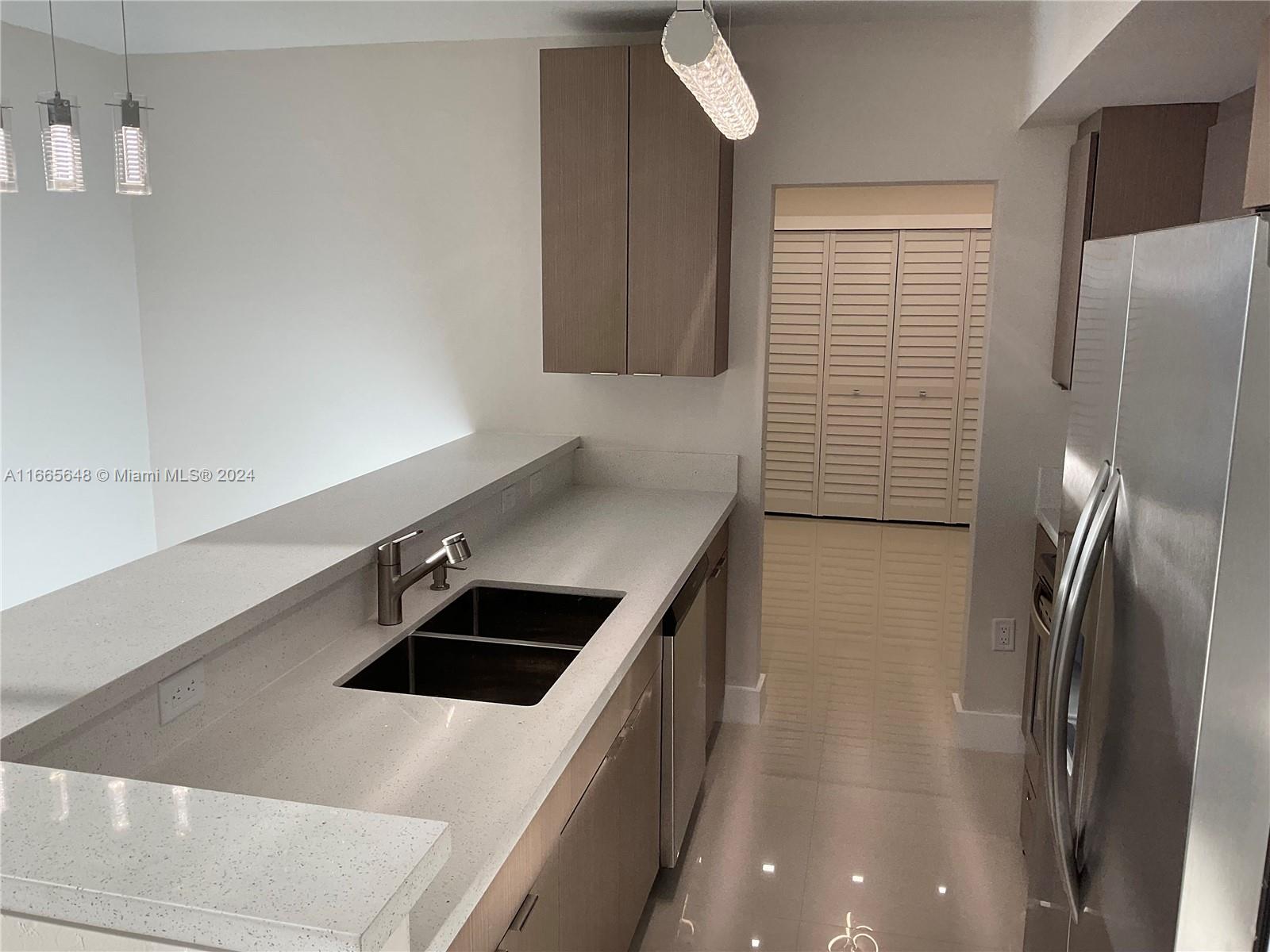 a kitchen with stainless steel appliances a refrigerator sink and stove