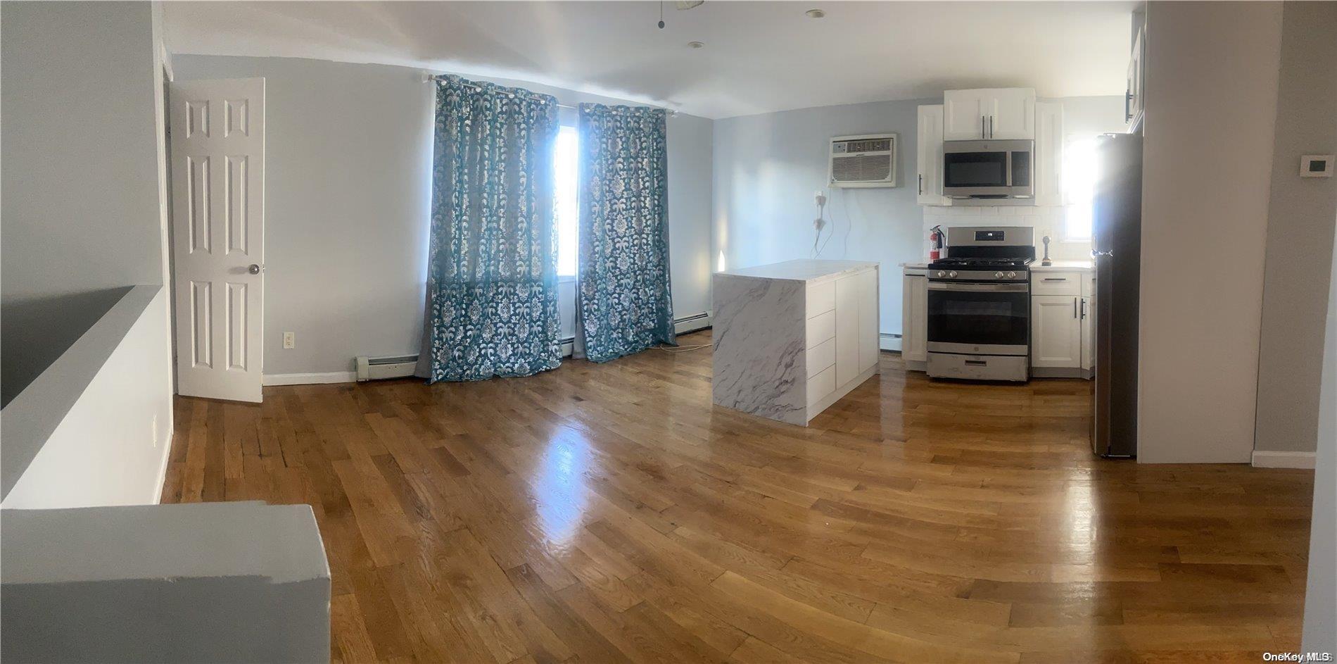 a view of a kitchen with furniture and wooden floor