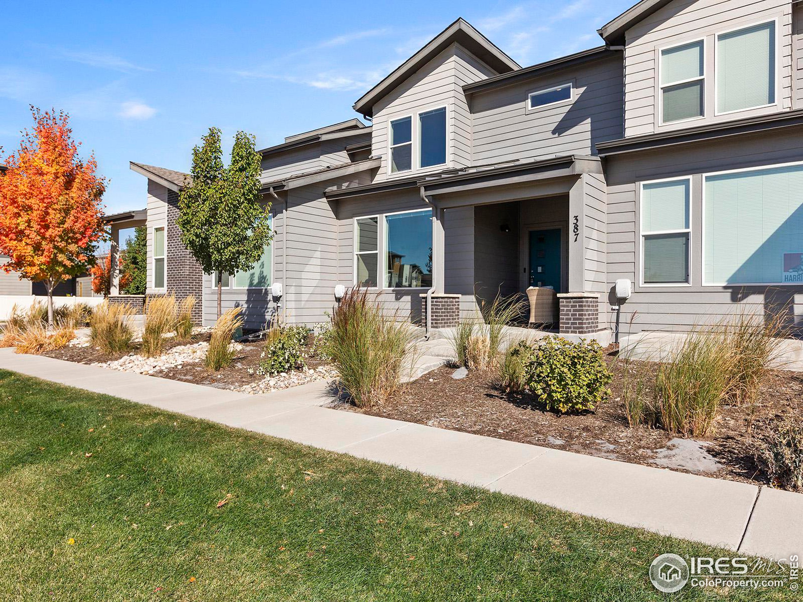 a front view of a house with a yard and potted plants