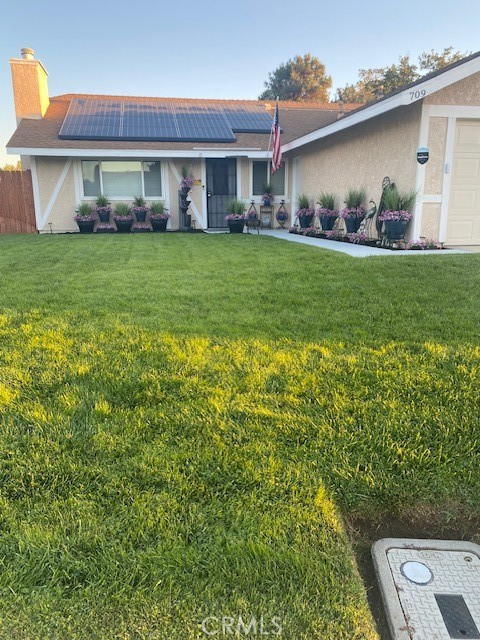 a view of a house with a big yard and potted plants