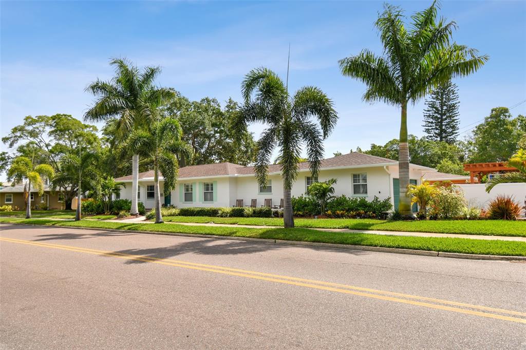 a front view of a house with a yard and trees