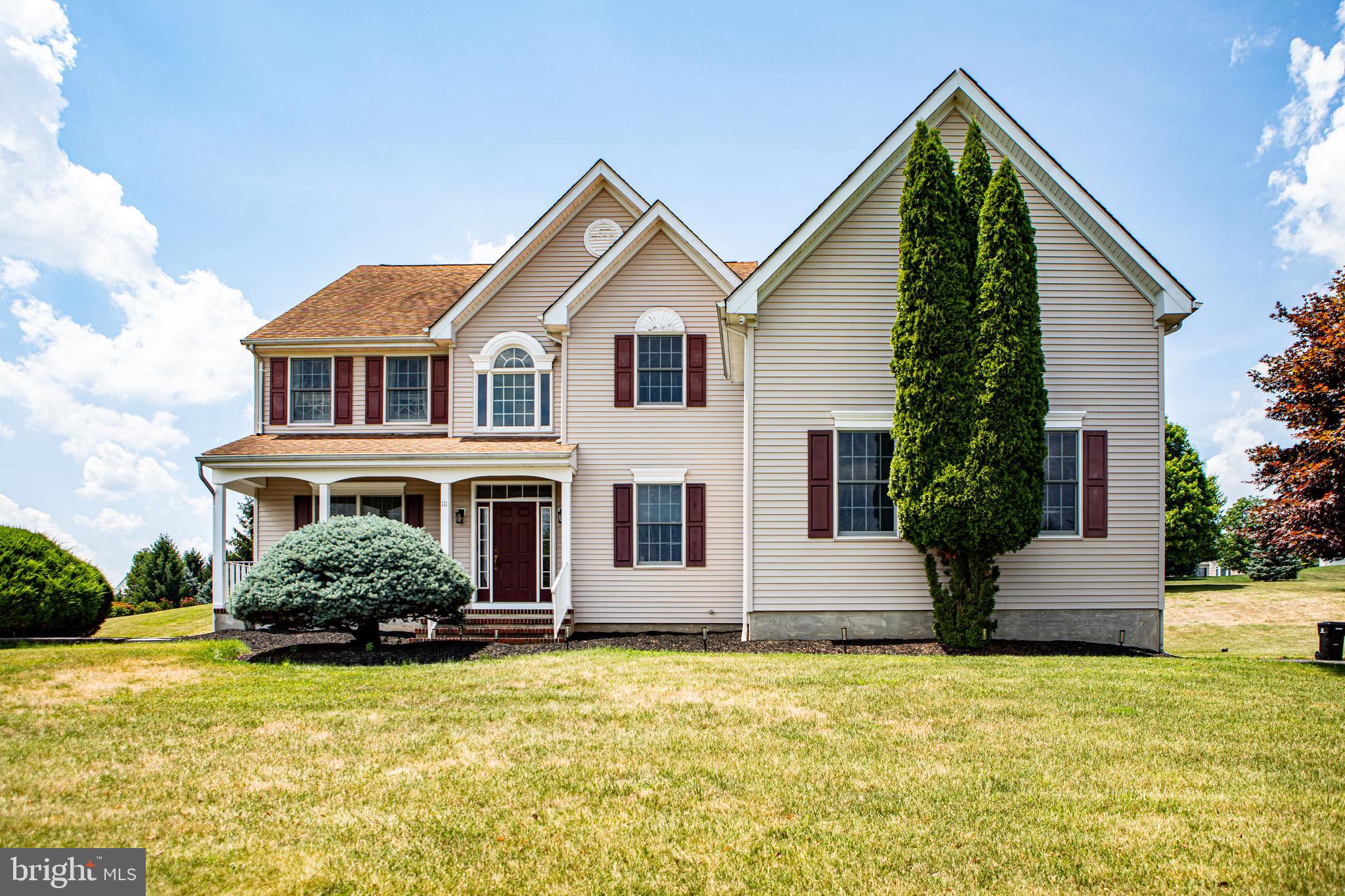 a front view of house with yard and trees around