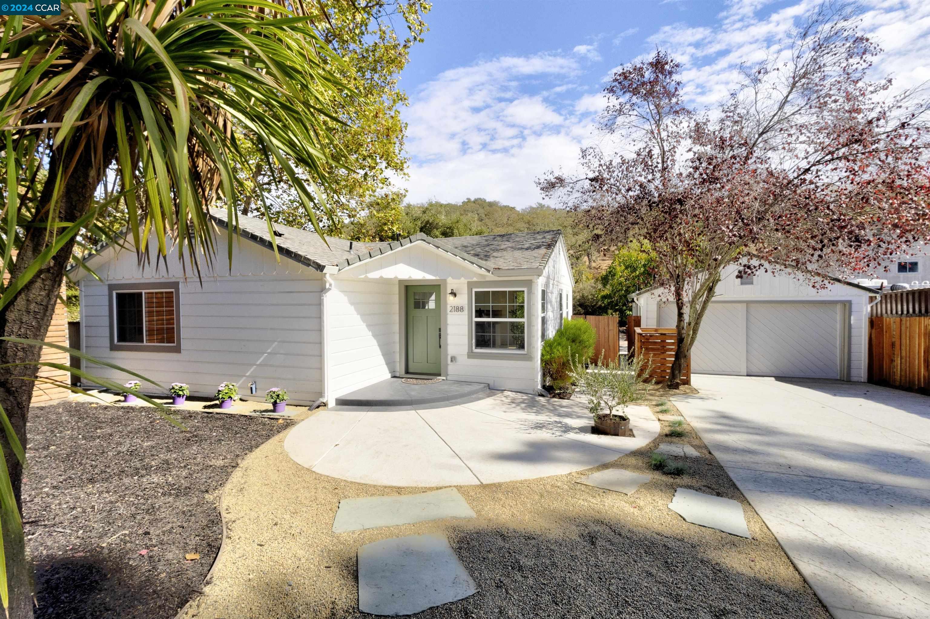 a view of a house with backyard and sitting area