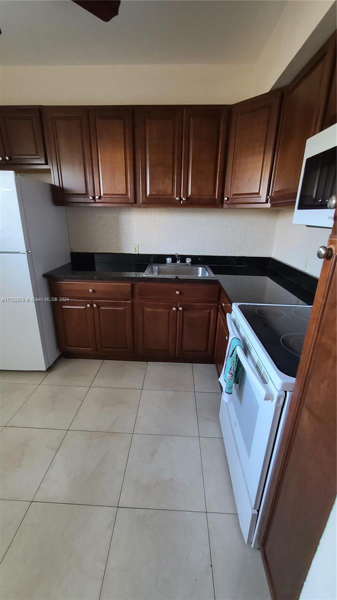 a kitchen with a sink a stove and cabinets