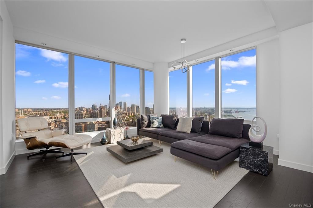 Living room with dark wood-type flooring and expansive windows