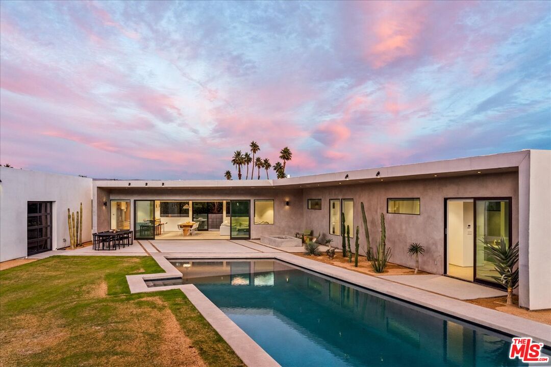 a view of a house with swimming pool and sitting area