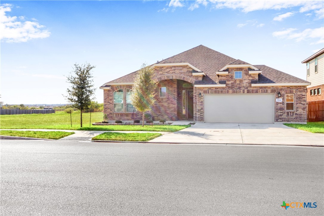 a view of a house with a yard and a garage