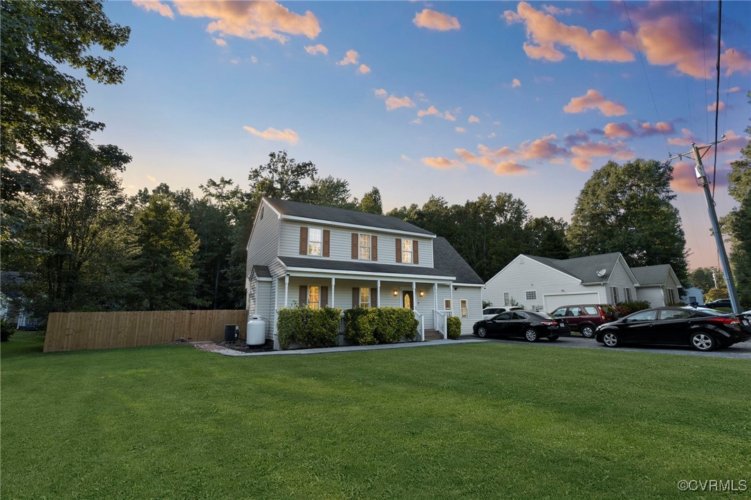 a front view of a house with a garden and trees