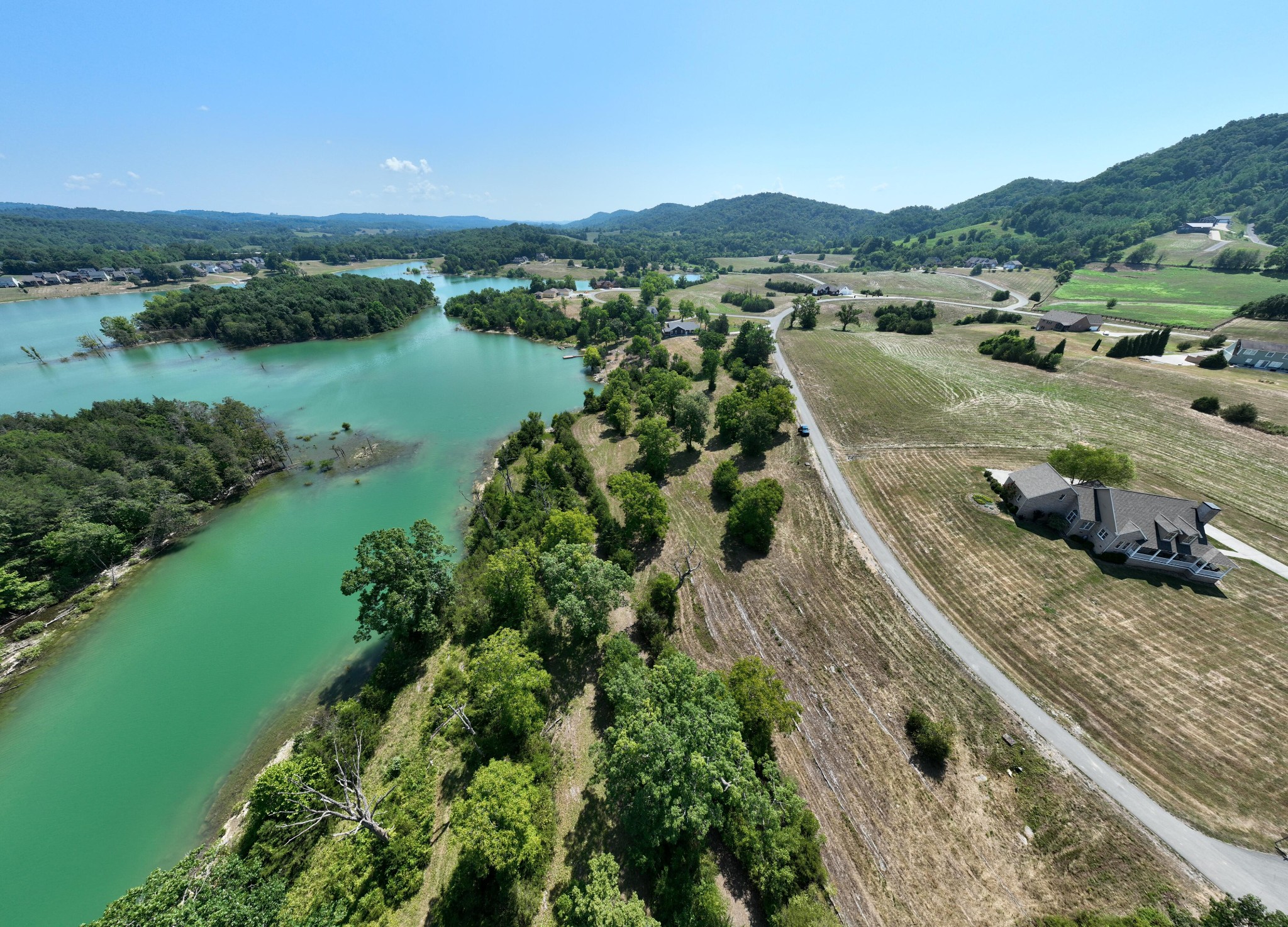 an aerial view of a house with a yard and lake view